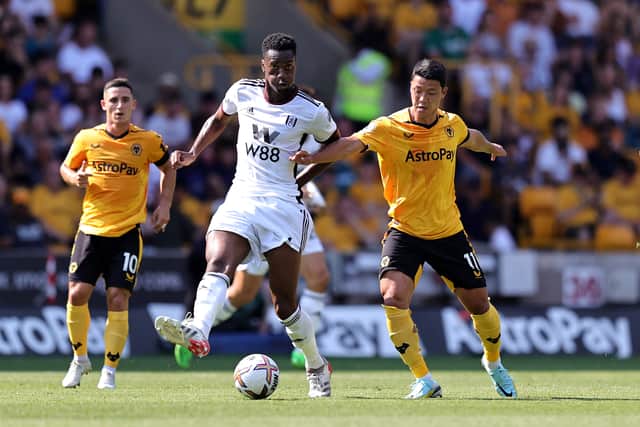Tosin Adarabioyo of Fulham is challenged by Hwang Hee-Chan during the Premier League match between Wolverhampton Wanderers and Fulham