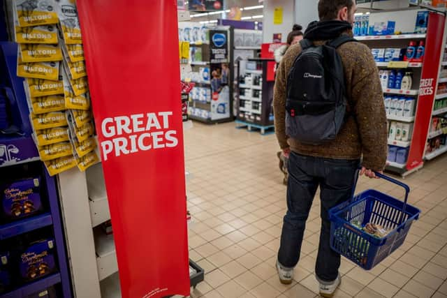 A customer carries their shopping in a basket at a Sainsbury’s supermarket in Walthamstow, east London on February 13, 2022. (Photo by TOLGA AKMEN/AFP via Getty Images)