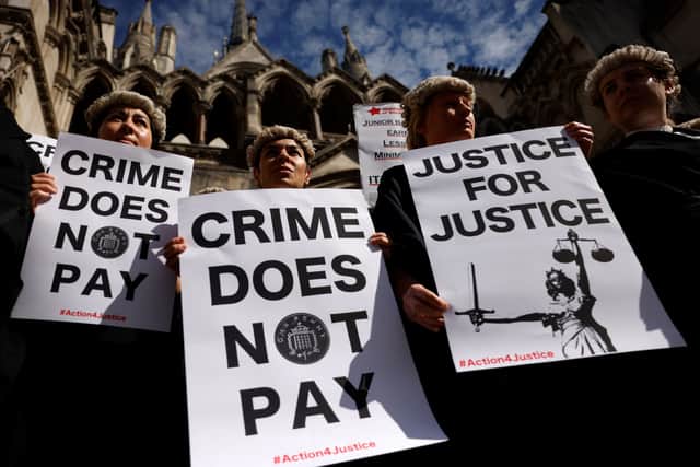 Senior criminal lawyers hold placards outside the Royal Courts of Justice, as they go on strike in a dispute over pay. Photo: Getty