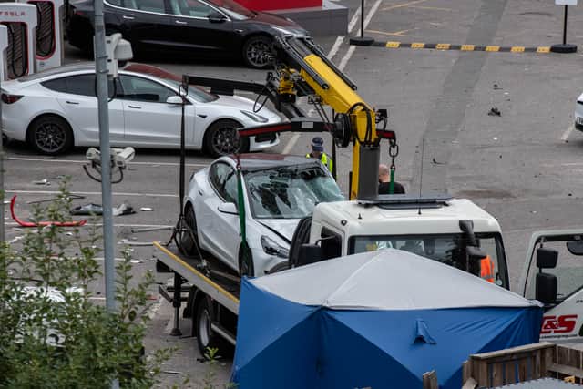 A Tesla car is loaded onto a truck at a Tesla garage after an incident at Park Royal tube station. Photo: Getty