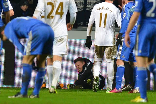 A ballboy (C) lies on the grounf and reacts after a altercation with Chelsea's Belgium midfielder Eden Hazard (Photo credit should read ANDREW YATES/AFP via Getty Images)