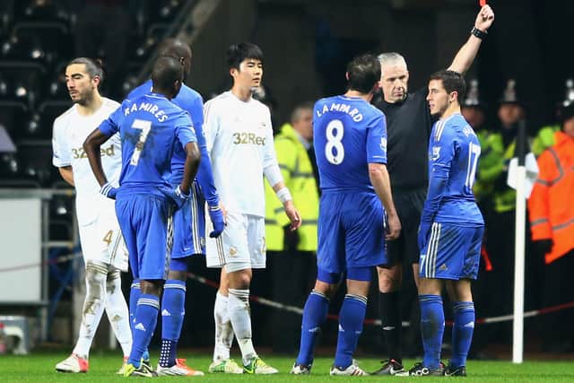 Eden Hazard of Chelsea (R) is sent off by referee Chris Foy after kicking a ball boy during the Capital One (Photo by Michael Steele/Getty Images)
