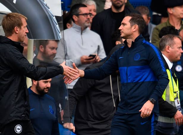 <p>Chelsea’s English head coach Frank Lampard (R) shakes hands with Brighton’s English manager Graham Potter (L). (Photo credit should read GLYN KIRK/AFP via Getty Images)</p>