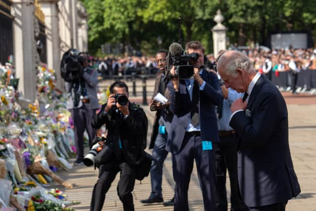 King Charles III views tributes to his mother, Queen Elizabeth II, as he arrives at Buckingham Palace. Photo: Getty