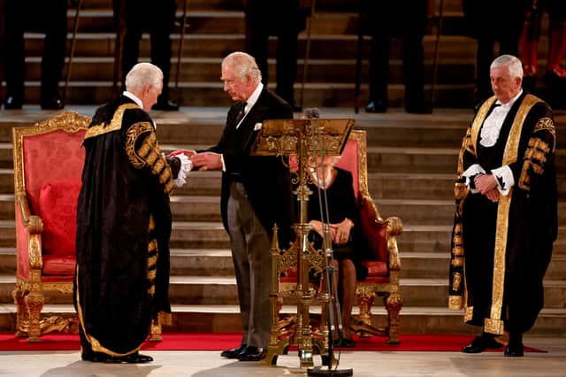 Speaker of the Commons Lindsay Hoyle (R) watches as Lord Speaker John McFall (L) presents Britain’s King Charles III with an item. Photo: Getty