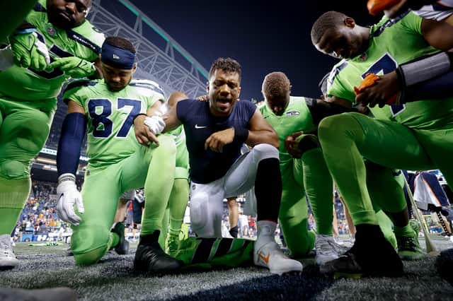 Russell Wilson #3 of the Denver Broncos (C) leads teams in prayer following a game between the Seattle Seahawks and the Denver Broncos