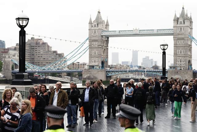 Members of the public in the queue on the South Bank near to Tower Bridge, London, as they wait to view Queen Elizabeth II lying in state ahead of her funeral on Monday. Credit: PA