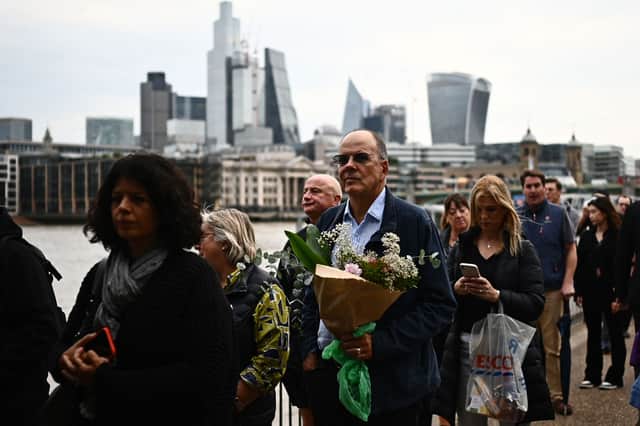 Mourners with flowers and Tesco carrier bags line the River Thames. Photo: Getty