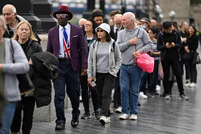 Royal fan Joseph Afrane, wearing Union flag-themed glasses, stands in the queue on the South Bank. Photo: Getty