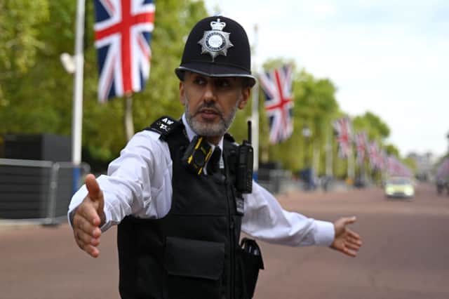 A policeman directs traffic on The Mall outside Buckingham Palace. Photo: Getty