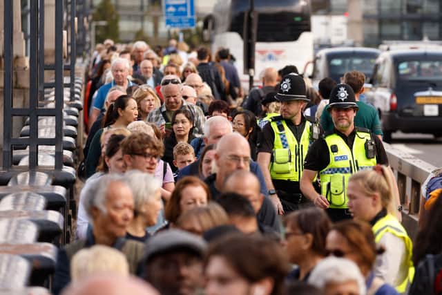 Police officers mingle with members of the public queuing on Lambeth Bridge as they wait in line to pay their respects. Photo: Getty
