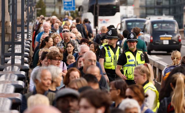 Police officers mingle with members of the public queuing on Lambeth Bridge as they wait in line to pay their respects. Photo: Getty