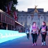 Back of the pack runners on The Mall heading towards the finish line at the end of the 2021 Virgin Money London Marathon