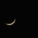 The planet Venus appears close to the crescent Moon as Jupiter (R) appears nearby during a rare planetary alignment in 2008.