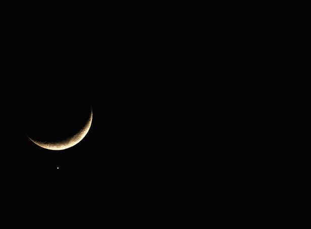 <p>The planet Venus appears close to the crescent Moon as Jupiter (R) appears nearby during a rare planetary alignment in 2008.</p>