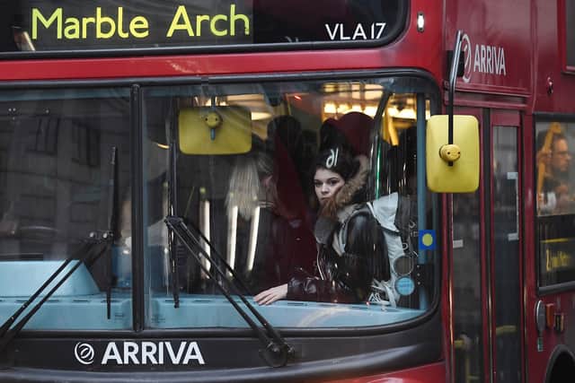 A woman looks out through a window on a crowded bus at Victoria Station. Photo: Getty
