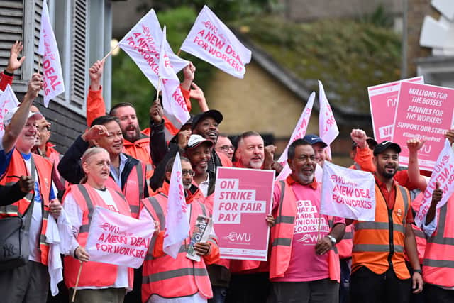 Royal Mail postal workers hold placards and chant slogans as they stand on a picket line. Photo: Getty