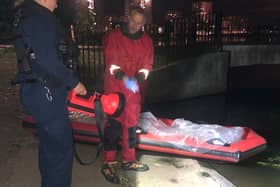 Marine Unit officers recovering the bodies of four dogs that were found dead inside plastic bags in Southmere Lake. Photo: Vicki Hudson / SWNS