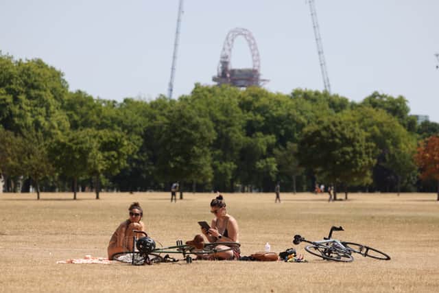 Women sunbathe, amid worries about the heat’s impact on rail infrastructure. (Photo by Hollie Adams/Getty Images)