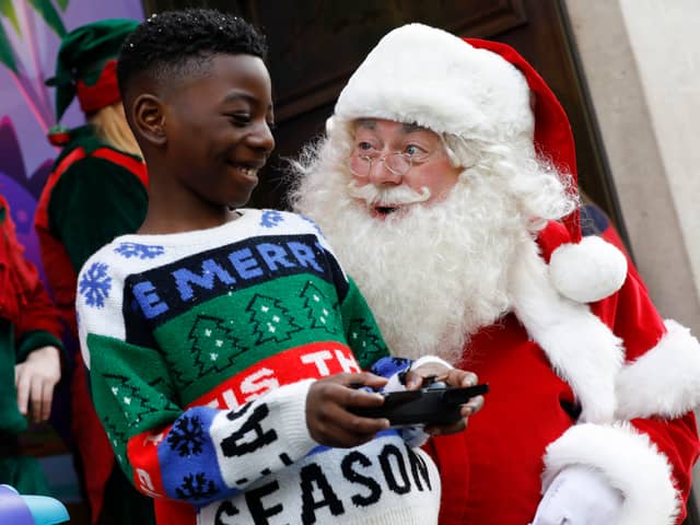 Santa and children play with a Jumping Sumo toy at Hamleys