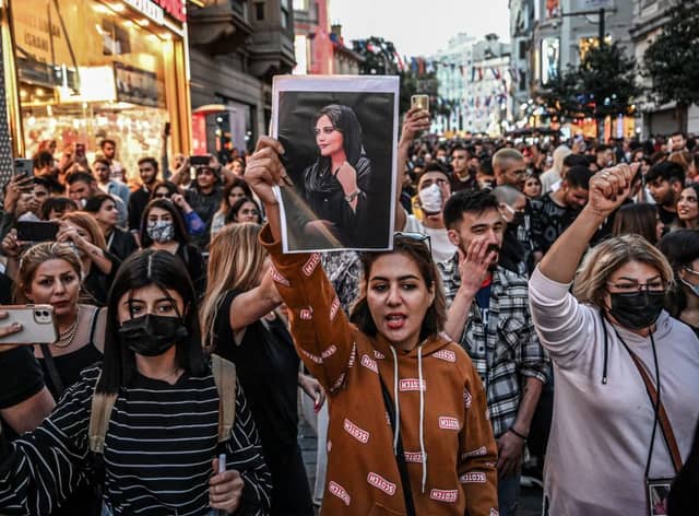 A protester holds a portrait of Mahsa Amini  during a demonstration. Credit: Getty Images