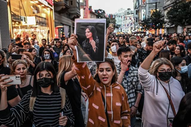A protester holds a portrait of Mahsa Amini  during a demonstration. Credit: Getty Images