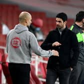Pep Guardiola, Manager of Manchester City bumps fists with Mikel Arteta, Manager of Arsenal (Photo by Shaun Botterill/Getty Images)