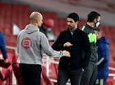 Pep Guardiola, Manager of Manchester City bumps fists with Mikel Arteta, Manager of Arsenal (Photo by Shaun Botterill/Getty Images)