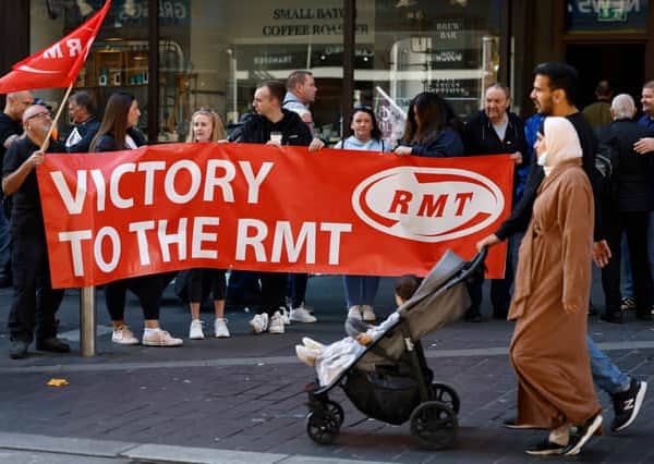 Rail workers stand on a picket line during the RMT strike on 27 July 2022