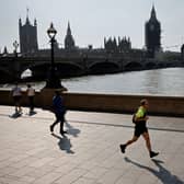 A jogger runs along the south bank of the River Thames, opposite the Houses of Parliament