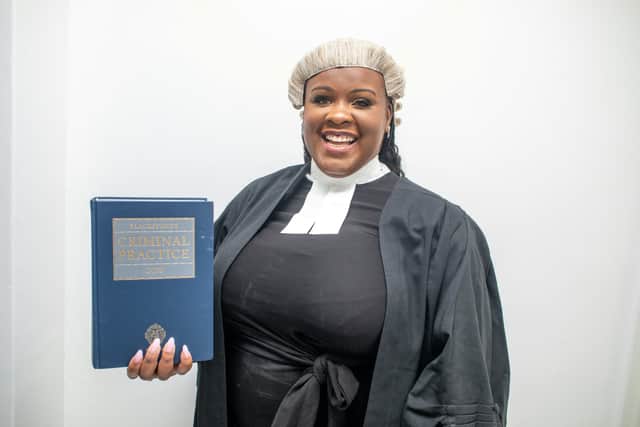 Jessikah Inaba stands holding a book titled Criminal Practice. Photo: SWNS