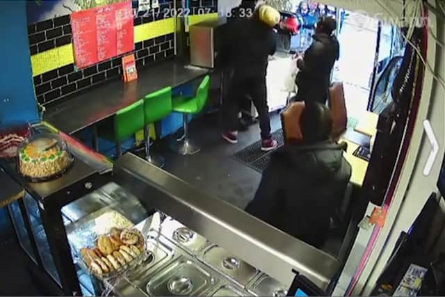 This is the moment a restaurant owner tackles a knifeman in his shop. Photo: Julius Cools/ SWNS
