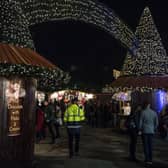 LONDON, ENGLAND - DECEMBER 21:  A security marshal walks amongst Christmas stalls and past a couple holding hands at the Winter Wonderland in Hyde Park on December 21, 2016 in London, England. Winter Wonderland is an annual event in London's Hyde park with fair ground rides, Christmas stalls, markets and entertainment for all ages. Security at major landmarks and events has been increased following the attack in the Berlin market outside the Kaiser Wilhelm Memorial Church.  (Photo by Chris J Ratcliffe/Getty Images)
