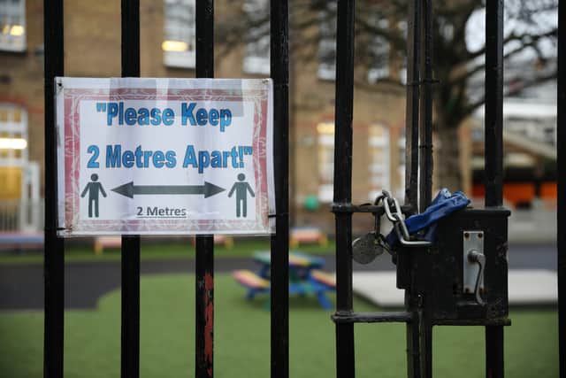 A social distancing sign hangs on a primary school gate in the Borough of Lewisham on January 04, 2021 in London, England. 