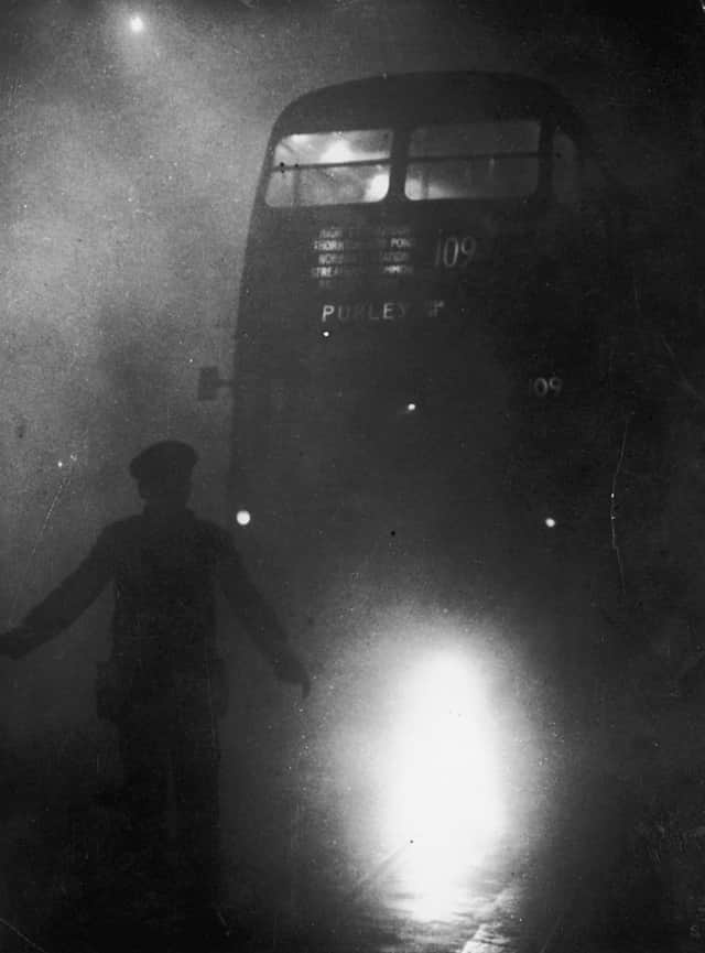 A London bus conductor is forced to walk ahead of his vehicle to guide it through the smog, December 9 1952. Credit: Getty Images