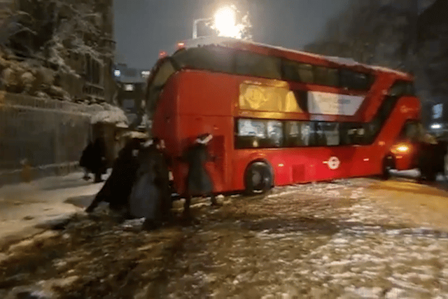 Londoners banded together to move a double-decker bus that got stuck during heavy snowfall. Photo: SWNS