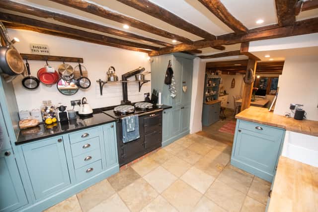 The cottage kitchen features blue cabinets and an Aga. Photo: SWNS