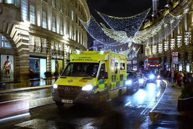 An ambulance queues in traffic beneath the Christmas decorations on Regent Street. Photo: Getty