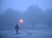 A walker makes their way through fog on a frosty morning at Primrose Hill in north London. (Photo by Justin TALLIS / AFP) (Photo by JUSTIN TALLIS/AFP via Getty Images)