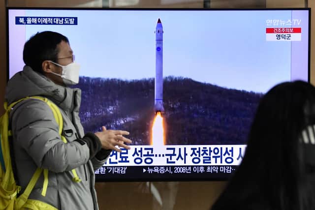 A man walks past a television screen showing a news broadcast with file footage of a North Korean missile test, at a railway station in Seoul on December 31, 2022 after North Korea fired three short-range ballistic missiles according to South Korea's military.