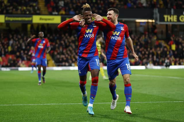  Wilfried Zaha celebrates with teammate James McArthur of Crystal Palace after scoring their team's third goal during the Premier League match