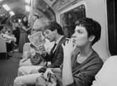 A woman smoking a cigarette on a London Underground train, London, June 21 1984.