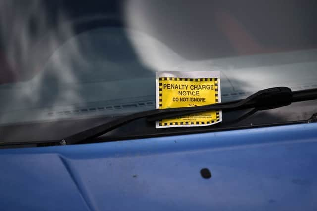 A Penalty Charge Notice (PCN) or parking ticket is pictured attached to the windscreen of a van in south London. Credit: DANIEL LEAL/AFP via Getty Images