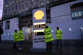 Greenpeace UK activists target Shell headquarters with a huge, mock petrol station price board, displaying its £32.2bn profits.