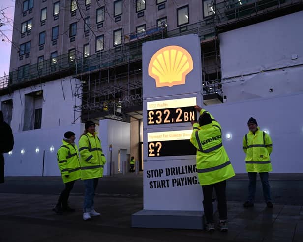 Greenpeace UK activists target Shell headquarters with a huge, mock petrol station price board, displaying its £32.2bn profits.