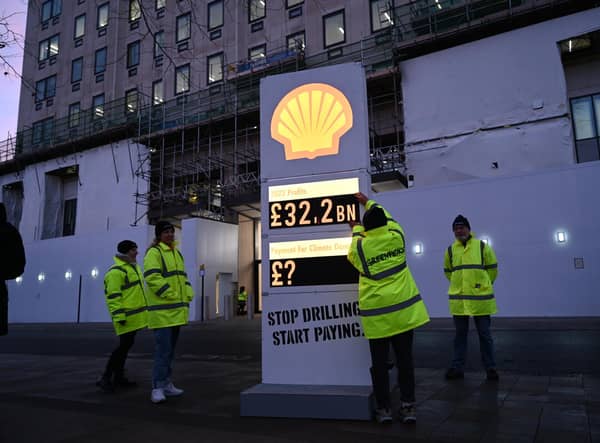 Greenpeace UK activists target Shell headquarters with a huge, mock petrol station price board, displaying its £32.2bn profits.