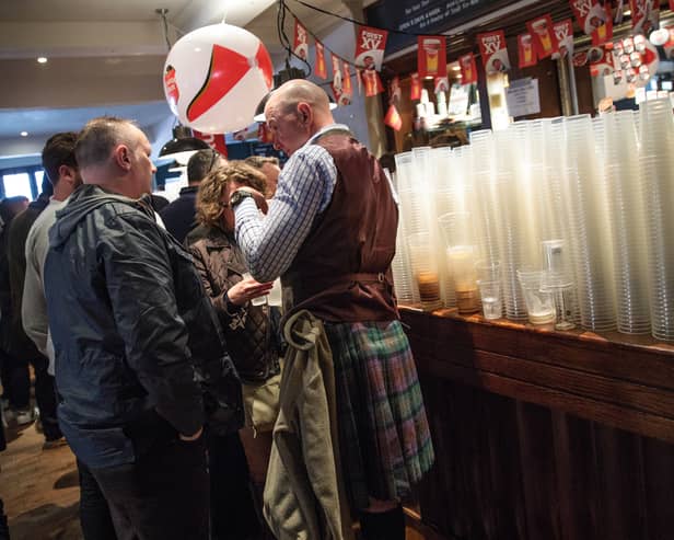 Plastic cups are seen stacked up on a bar as rugby fans gather in a London pub ahead of the England v Scotland match on March 11, 2017.