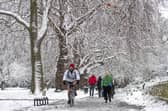 A person cycling through the snow in Kennington Park, London