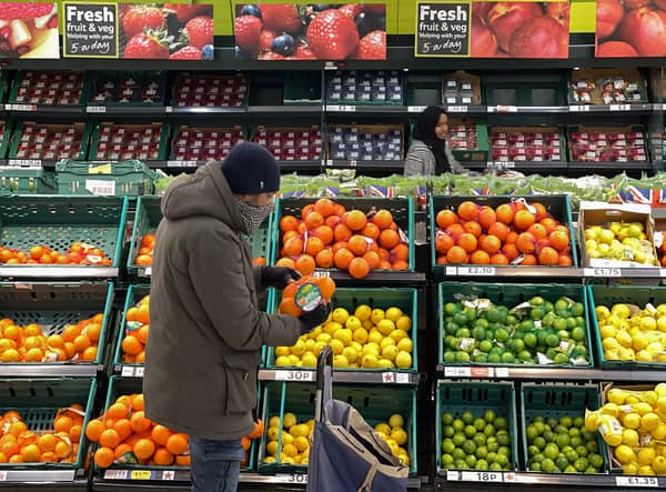 A customer shops for food items inside a Tesco supermarket store in east London on January 10, 2022.  (Photo by DANIEL LEAL/AFP via Getty Images)