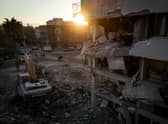 Men walk down a street amid rubble from destroyed buildings on February 20, 2023 in Hatay, Turkey